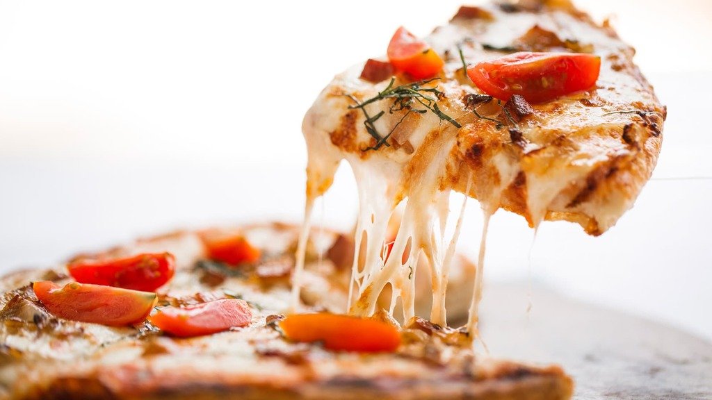 A slice of Flower pizza with the cheese stretching
