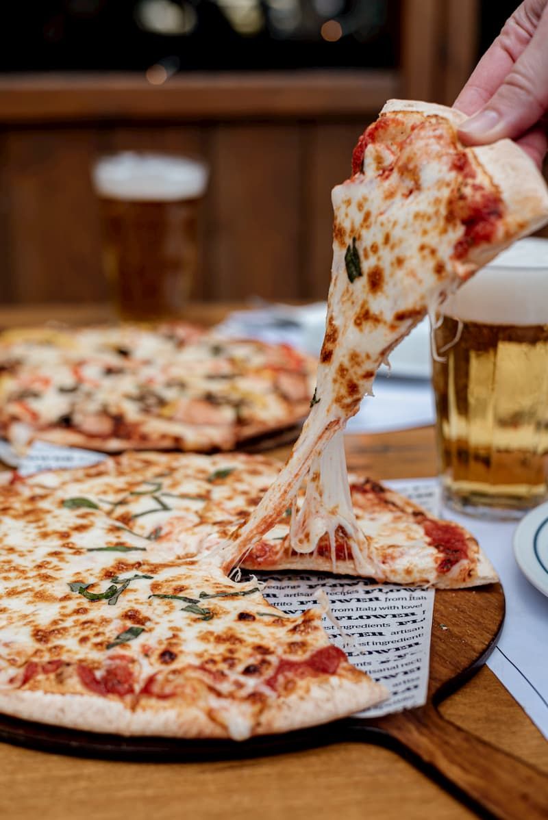 A slice of pizza being lifted, the cheese stretching